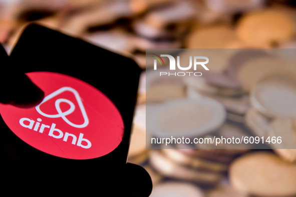 In this photo illustration a Airbnb logo is displayed on a smartphone screen and Euro coins as background on a computer screen in Athens, Gr...