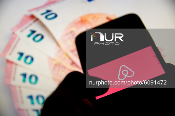 In this photo illustration a Airbnb logo is displayed on a smartphone screen and Euro bills as background on a computer screen in Athens, Gr...