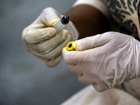 A health worker draws a blood sample from a person for use in the 4th round of serological survey testing for coronavirus, at a dispensary i...