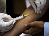 A health worker draws a blood sample from a person for use in the 4th round of serological survey testing for coronavirus, at a dispensary i...