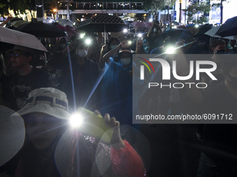 Thai protesters hold up flashlights on the phones during rally against the state of emergency at Ratchaprasong shopping district in Bangkok,...