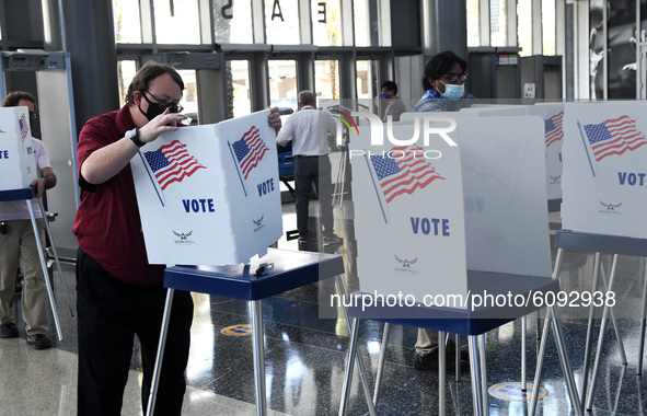 Election workers set up voting booths at an early voting site established by the City of Orlando and the Orlando Magic at the Amway Center,...