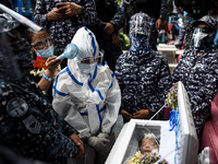 Political detainee Reina Mae Nasino, wearing a full personal protective equipment (PPE), attends the burial of her three-month-old baby at a...
