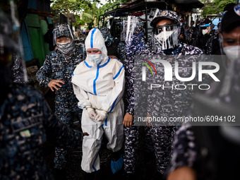 Political detainee Reina Mae Nasino, wearing a full personal protective equipment (PPE), leaves the cemetery after the burial of her three-m...