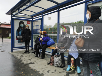 People wear face masks while waiting on a bus stop during coronavirus pandemic. Krakow, Poland on October 14th, 2020. Due to the increasing...