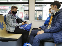 Boys wear face masks while travelling on a tram during coronavirus pandemic. Krakow, Poland on October 14th, 2020. Due to the increasing spr...