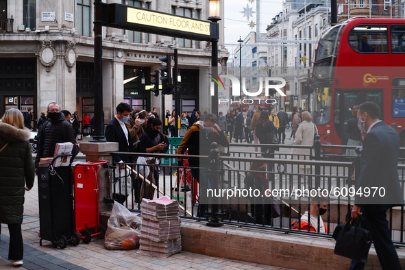 People wearing face masks, required on public transport, enter Oxford Circus Station in London, England, on October 16, 2020. London is to b...