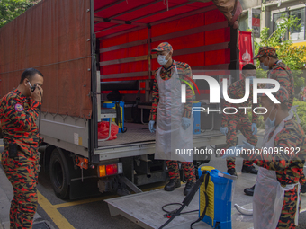 Firefighters load their equipment into a truck after a disinfection process in Kuala Lumpur, Malaysia, on  October 17, 2020. 
Malaysias capi...