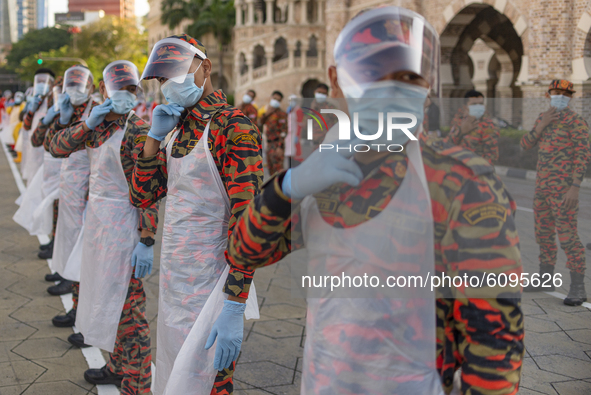 Firefighters wearing face shield warm up before a disinfection process begin in Kuala Lumpur, Malaysia, on  October 17, 2020. Malaysias capi...