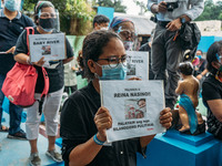 Friends of Filipino activist Reina Mae Nasino hold placards calling for justice during the burial of her three-month-old baby River, who die...