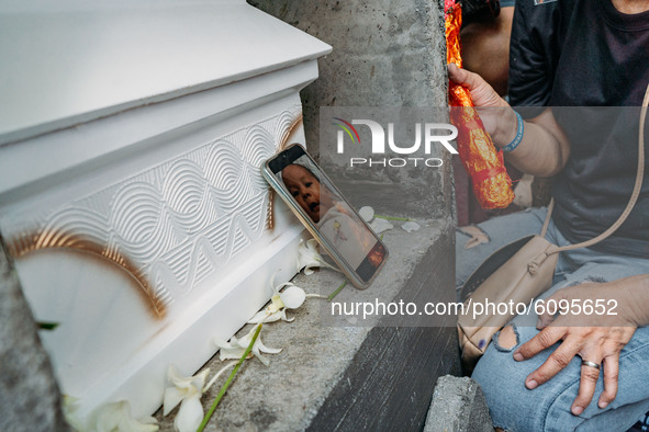 A digital photograph of three-month-old daughter of political detainee Reina Mae Nasino, is placed beside her coffin before she is buried, i...