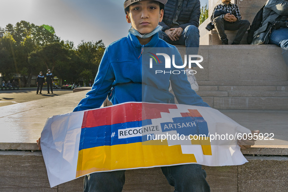 A kid holds a banner asking for the recognition of Karabakh as an independent state in the international community during a demonstration in...
