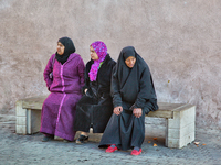 Women sit on a bench in the main square of the city of Meknes, Morocco, Africa. Meknes is one of the four Imperial cities of Morocco, locate...