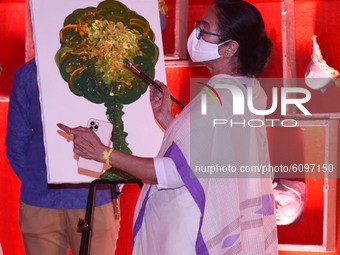 West Bengal Chief Minister Mamata Banerjee paints during  inauguration of  temporary platform  of  a community  Durga Puja pandal  is decora...