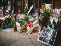 A photo shows flowers and a placard reading 'I am a teacher, I am Samuel' at the entrance of a middle school in Conflans-Sainte-Honorine, 30...