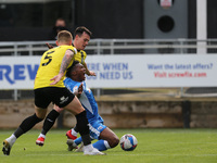 Kgosi Ntlhe of Barrow goes down in the penalty area after a challenge for Harrogate Town's  Will Smith and Connor Hall uring the Sky Bet Lea...