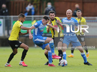 Barrow's Josh Kay battles for possession with Warren Burrell and Connor Hall during the Sky Bet League 2 match between Harrogate Town and Ba...