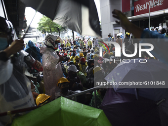 Thai protesters stand behind a barricade during an anti-government protest at the Victory Monument in Bangkok, Thailand, 18 October 2020. (