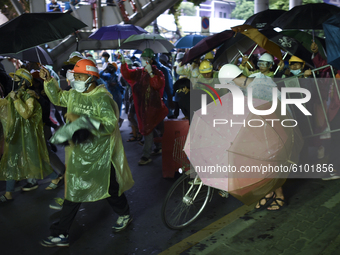 Thai protesters holding an umbrella and join a march at the Victory Monument during an anti-government protest in Bangkok, Thailand, 18 Octo...