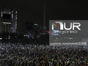 Thai protesters hold up mobile phones with flash lights during an anti-government protest at the Victory Monument in Bangkok, Thailand, 18 O...