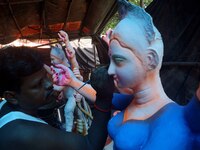 An image makers is seen at his workshop as he is applying colors into the goddess Durga idols before to supply them to the worship venues ah...