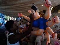 An image makers is seen at his workshop as he is applying colors into the goddess Durga idols before to supply them to the worship venues ah...