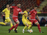 Alexandru Matan of Romania U21 in action against Owen Spiteri and Gary Camilleri of Malta U21 during the soccer match between Romania U21 an...