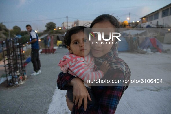 Siblings posing for a picture at the roof of a building where they lived after the fire of Moria camp. Portraits of young children refugees,...