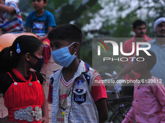 Local children wearing protective mask watch traditional Ramleela,a play narrating the life of Hindu God Ram,ahead of Dussehra festival,duri...