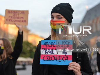 Pro-Choice activist holds a sign that says 'Abortion Is A Human Right', seen in the center of Krakow, part of the Coronavirus Red Zone, duri...