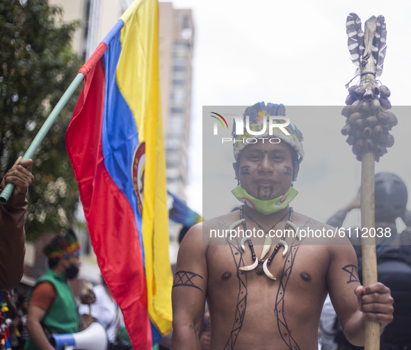 Indigenous men in the protest against the national government and rejecting the massacres and murder of social leaders in Bogota, Colombia,...