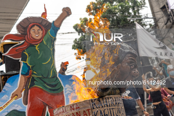 Protesters burn a effigy of President Duterte, who peasant groups say is guilty of burdening and persecuting farmers and the Filipino public...