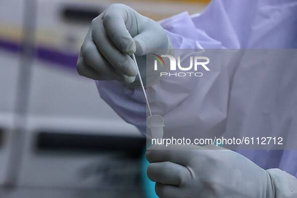 A medical worker places a swab sample into a tube for a Rapid Antigen Test (RAT) for the Covid-19 coronavirus in Sopore, district Baramulla,...