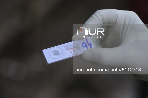 A health worker show positive swab sample  collected for Rapid Antigen Test (RAT) for the COVID-19 coronavirus at a testing center in Sopore...