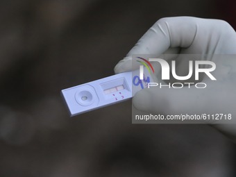 A health worker show positive swab sample  collected for Rapid Antigen Test (RAT) for the COVID-19 coronavirus at a testing center in Sopore...