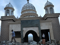 A husband and wife look at the condition of the Al-Arqam mosque, in Besusu Village, Palu City, Central Sulawesi, Indonesia, Thursday, Octobe...