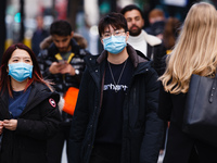 A man and woman wear face masks amid shoppers on Oxford Street in London, England, on October 22, 2020. Retail sales figures from the UK Off...