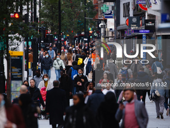 Shoppers, some wearing face masks, walk along Oxford Street in London, England, on October 22, 2020. Retail sales figures from the UK Office...