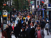 Shoppers, some wearing face masks, walk along Oxford Street in London, England, on October 22, 2020. Retail sales figures from the UK Office...