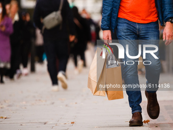 A man carries bags of shopping along Oxford Street in London, England, on October 22, 2020. Retail sales figures from the UK Office for Nati...