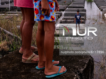 Children skip on submerged tombs inside a public cemetery in Pampanga province, north of Manila on October 24, 2020. Low-lying villages in t...