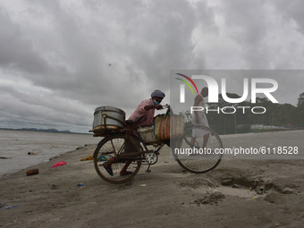 A fish vendor returned  home  after  cleans his bicycle and basket as dark clouds gather in the sky, in Guwahati, India on 24 October 2020....
