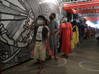 Visitors wating line to visit the outside at a community a temporary structure to perform during the Hindu festival 'Durga Puja' celebration...