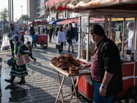 On 24 October, a simit vendor tries to sell his sesame bagels to Turkish people wearing face masks as they spend leisure time along the Kara...