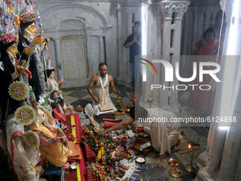 A Hindu priest  performing rituals in front of a statue of the ten-handed Hindu Goddess Durga at the 300 year old Barik Rajbari (Barik Royal...