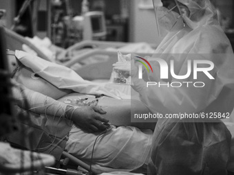 (EDITOR'S NOTE: IMAGE HAS BEEN CONVERTED TO BLACK AND WHITE) A medical worker in personal protective equipment (PPE) tends to a patient in t...