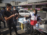 A female member of Iran Red Crescent Society (R) asks a man to wear a protective face mask to prevent himself of infection by the new corona...