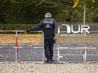 A policeman leans on fences during a demonstration under the motto Alarmstufe Rot (Alarm level red) during the second wave of the coronaviru...