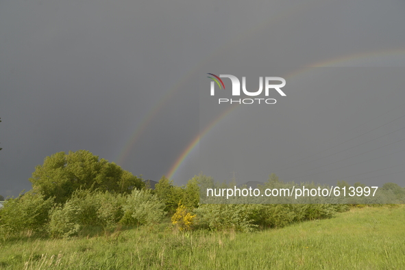 Sunlight refracting in rainwater to create a double rainbow, arching over power lines in Stockport, on Sunday 31st May 2015. -- A double is...