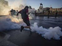 A person kicks a tear bomb dropped by riot police of carabineros de Chile (COP) on October 30, 2020 in Santiago de Chile, Chile. 
Amid of t...